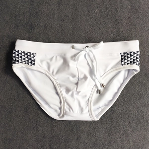 Detail of men's white swim briefs showing side triangle print and adjustable drawstring