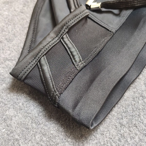 Detail of black bikini shorts with breathable mesh panels and silver metal aglets on drawstrings