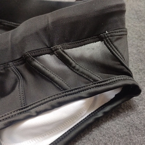 Detailed close-up of black mesh patchwork and premium stitching on bikini swim shorts