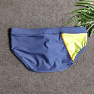 Close-up of men's navy blue swim briefs with bright neon green side panels and orange trim