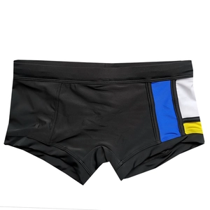 Detail view of men's swim trunks showing blue white and yellow side color splicing