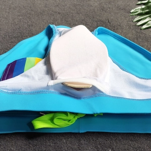 Detail of men's swim briefs with white mesh lining, pouch support, and green drawstring