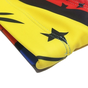 Detailed close-up of yellow swimwear fabric with star patterns and reinforced stitching