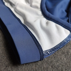 Detailed close-up of navy elastic waistband and white breathable mesh lining for swim trunks