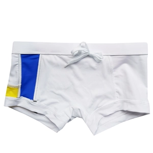 Detailed flat lay of white men's swim trunks with blue and yellow side patchwork design