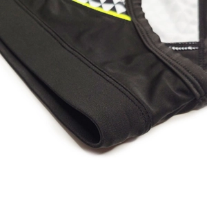 Detail showing high-density black swim fabric with yellow trim and geometric patterns