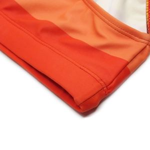 Detailed close-up of double-stitched seams on orange striped men's elastic swim briefs
