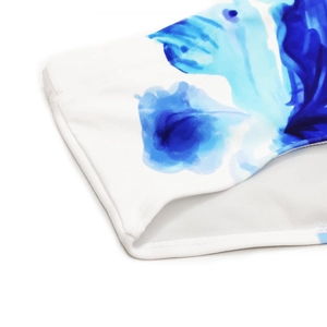 Detailed macro view of blue ink lily floral print on premium white swim trunk fabric