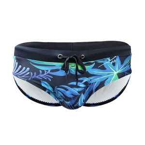 Detail of men's tropical palm leaf print swimwear with black drawstring and elastic waist