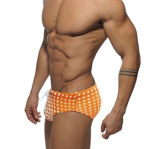 Detail of men's orange swim trunks with white polka dots and adjustable drawstring waist
