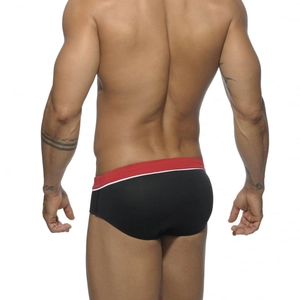 Rear view of black low-rise men's swim briefs with red and white contrast stripes