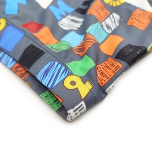Detail of colorful geometric print and durable stitching on men's stretch swim trunks