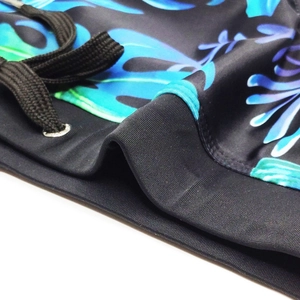 Detail of men's swim briefs featuring tropical leaf print and elastic drawstring waistband