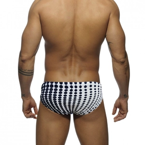 Rear view of white men's swim briefs featuring large navy blue polka dots and low-rise fit