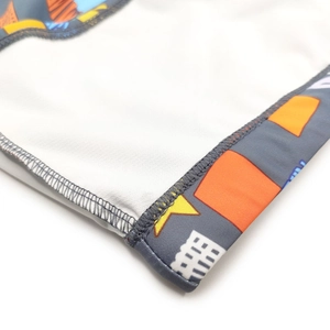 Detailed close-up showing precision double-needle stitching and knit fabric of men's swim trunks