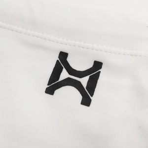 Detailaufnahme des schwarzen geometrischen Logos auf weißem Stoff der Herren Badehose