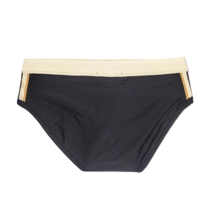 Flat lay of men's black swim briefs with cream waistband and orange side stripes