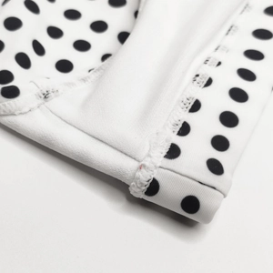 Close-up of double-needle stitching and black polka dot pattern on swim trunks