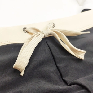 Macro detail of men swim briefs with contrast waistband, metal eyelets and woven drawstrings