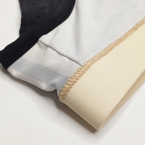 Macro shot of men's swim briefs featuring fine white mesh fabric and black elastic piping