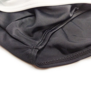 Macro detail of reinforced double-needle stitching on men's black elastic swim briefs