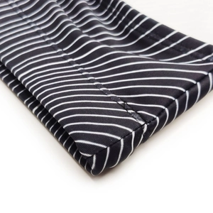 Detail of swimsuit elastic waistband featuring bold black and white horizontal stripes