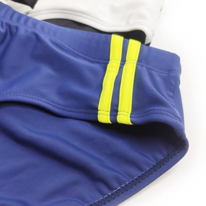 Detail of royal blue swim briefs with neon yellow side stripes and elastic waistband