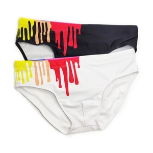 Detail of men's swim briefs with colorful paint drip prints on black and white fabric