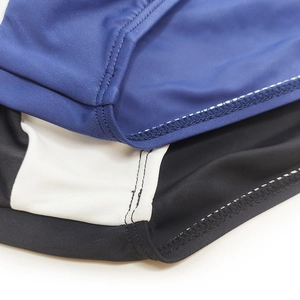 Detailed stitching and fabric texture of men's tri-color patchwork swim briefs