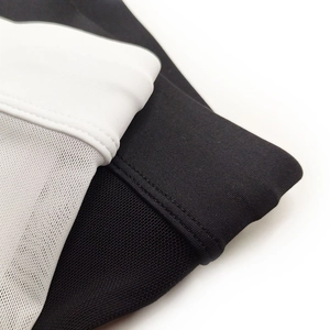 Macro detail of men's swimming trunks showing mesh splicing and premium sewing craft