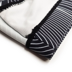 Detailed close-up of neat black edge stitching on black and white striped swim briefs fabric