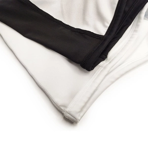 Detail of men's swimming trunks featuring black mesh fabric and white stitching