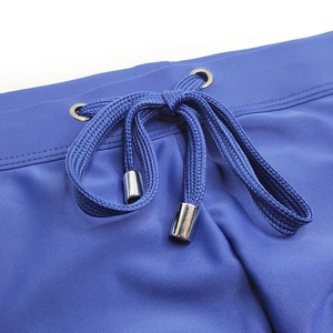 Détail du maillot de bain bleu roi montrant la texture et les embouts de cordon