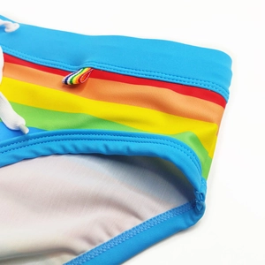 Detail of blue men's swim briefs featuring rainbow stripes and a white drawstring