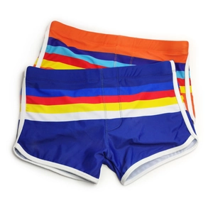 Detail of blue and orange swim trunks with colorful striped waist and white piping trim