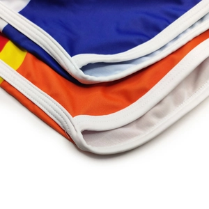 Detail of colorful striped men's swim trunks with white elastic trim and reinforced stitching