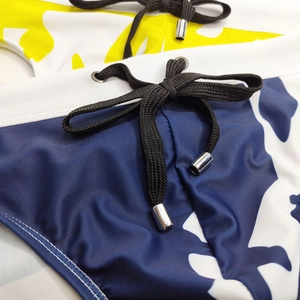 Dettaglio slip da nuoto uomo con vita elastica, coulisse nera e punte in metallo argentato