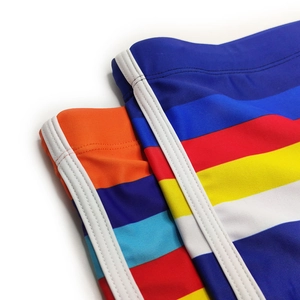 Close-up of men's colorful striped swim trunks showing fabric texture and side stripe detail