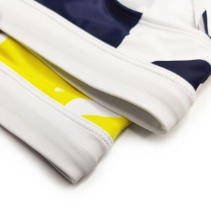Dettaglio cucitura a doppio ago su tessuto elastico per costumi bianco blu e giallo
