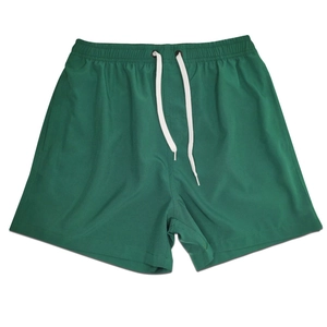 Detail of dark green quick-dry men's sports shorts with elastic waist and white drawstrings