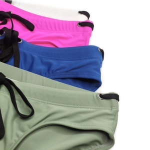 Detail view of elastic men's swim briefs with adjustable black drawstrings and metal eyelets