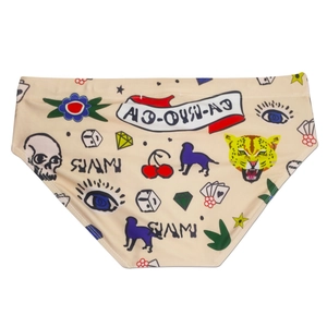 Detailed view of men's beige swim briefs with American retro tattoo style print patterns
