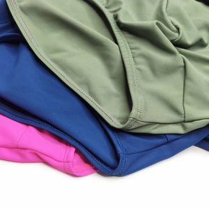 Detailed close-up of quick-dry men's swim briefs in olive green, blue and pink colors
