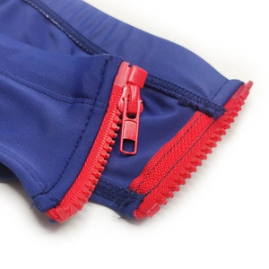 Detail view of high-elastic navy blue fabric with a contrasting bold red resin zipper