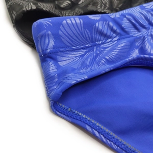 Detailed macro view of men's blue swimwear fabric featuring metallic shell texture