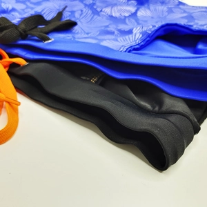 Detail of hibiscus print and solid black swim trunks with contrast drawstring waistbands
