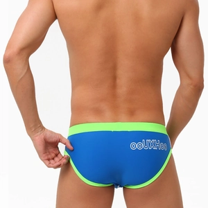 Close-up of royal blue men's swim briefs with lime green trim and logo detail on the back