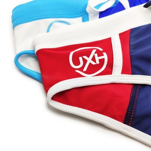 Close-up of color-block swim briefs with UXH logo and drawstring detail