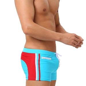 Detail of blue swim trunks showing the functional zipper pocket and striped side panels