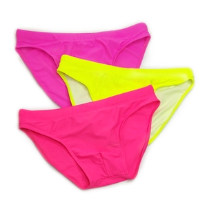 Flat lay of three low-waist men's swim briefs in neon pink, magenta, and fluorescent yellow